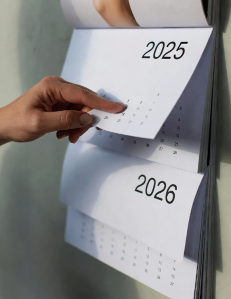 close up hand pulling back 2025 calendar revealing 2026 image created with Grok AI